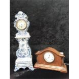 A large blue and white china clock together with a John Elkan wooden mantle clock.