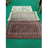 A collection of three carpets. Red: 61×35 inches, Brown: 61×31 inches, Cream: 49×28 inches.