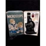 A retro boxed children's microscope with three glass slides.