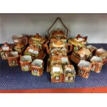 A quantity of Price Brothers china thatched cottages.