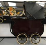 Early 20th century doll's pram with large maroon bucket base, canopy, removable panels to reveal