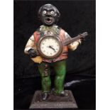 A cast iron French cigar bar lighter designed as a happy banjo player decorated in yellow green