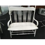A beech framed American two seater porch settee on turned legs and spindle back.