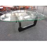 A Herman Miller Noguchi design folding black framed kidney shaped coffee table with glass top.
