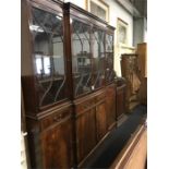 A large reproduction breakfront bookcase with four glass panels above with drawers and cupboards