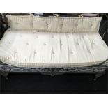 A large French day bed with iron frame.