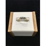 An 18ct three stone diamond ring in an illusion setting.