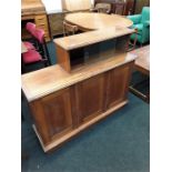 An oak sideboard with three cupboards under glass section.