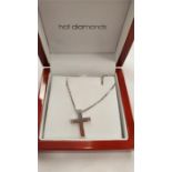 A boxed silver and diamond cross on chain.
