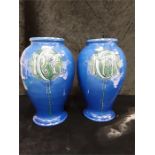 A pair of Brannam of Barnstaple blue glazed pottery vases, with family Cartouche initial possibly