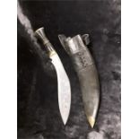 A metal bound kukri with sheath.