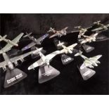 Ten diecast world war two aircraft on display stands.