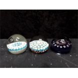 Three glass paperweights in millefiori patterns.