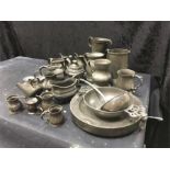 A box of pewter to include warming dish, ladle, porringer etc.