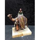A 1920s spelter match striker on marble base designed as a camel and two gentlemen in native