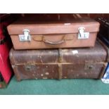 A wood bound travel trunk together with a suitcase.