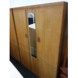 A large teak double wardrobe with central mirror.