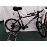 A Carrera mountain bike. 24 speed with front suspension, mechanical disc brakes, lights and a