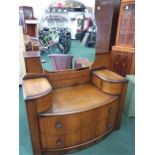 A bow fronted dressing table with central mirror.