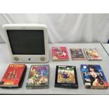 An eMac computer along with a collection of various computer games.