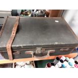 A vintage suitcase with leather edge and handle, brass clasp and glass and silver plate topped