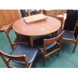 A circular extendable dining table with six chairs.