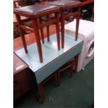 A retro dining table with four stools.