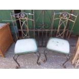 A pair of wrought iron conservatory chairs.