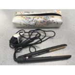 A GHD hair straightener with a box of necklaces.