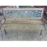 A cast iron garden bench with rose reliefs to back.