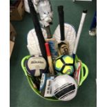 A container of footballs, cricket bats and other sporting equipment.