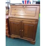 A pine bureau with double cupboard under.