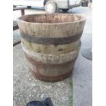 A pair of oak half barrel planters and a small glass top table.