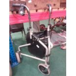 A folding disability walking frame with fitted shopping bag.