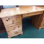 A pine four drawer desk.