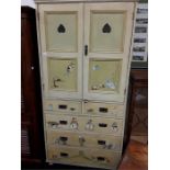 A painted children's/school cupboard with two and three drawers under top section. Decorated with