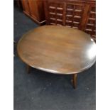 An oval shaped dark Ercol style coffee table.