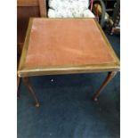 A mahogany felt topped card table with fold up legs.
