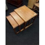 A teak mid 20th century nest of three tables.