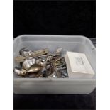 A box of collectable spoons, badges etc.