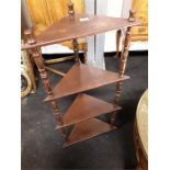 A mahogany corner whatnot/shelving unit with four shelves.