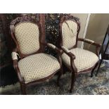 A pair of french design carved back elbow fautile chairs in floral tapestry.