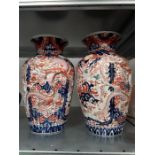 A pair of large Japanese Imari vases decorated with dragons in blue and red.