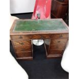 A leather top mahogany pedestal desk with nine drawers.