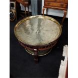 A small circular side table with brass top