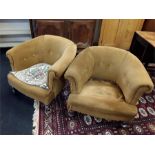 A pair of bucket armchairs with gold coloured fabric. In need of re upholstery.