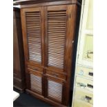 A colonial mahogany wardrobe with panelled louve fronts. Drawers in centre with shoe cupboard to
