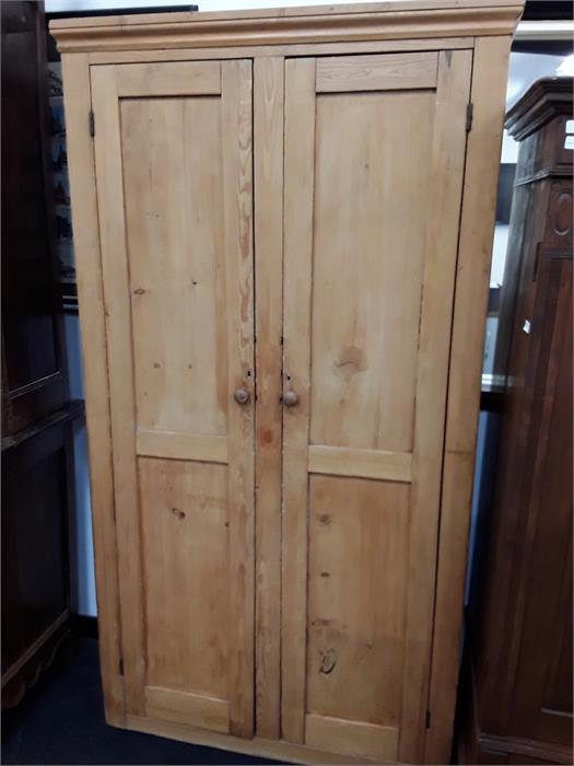 A large pine double door wardrobe.