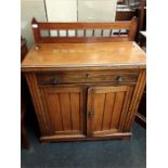 An antique walnut sideboard with one drawer over two cupboard doors.