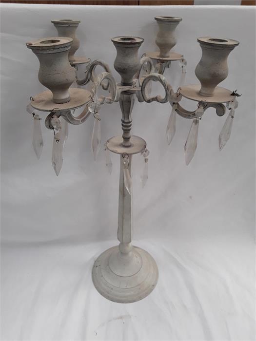 A painted metal five holder candelabra with glass droplets.